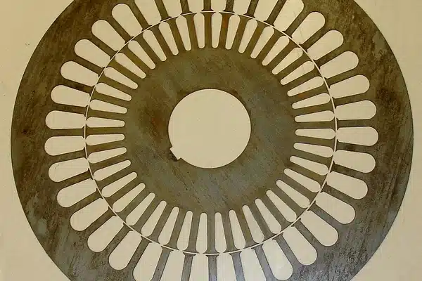 A stator lamination and a rotor lamination punched from the same electrical steel sheet, shown before separation