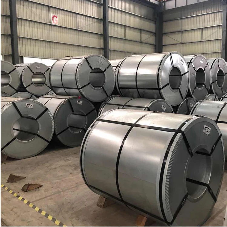 Rows of stacked silver electrical steel coils in a warehouse bay marked with a large letter G on the wall 