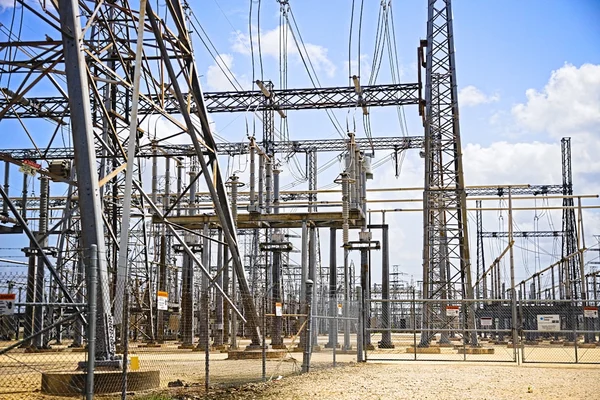Electrical substation with distribution transformers and overhead power lines under a clear sky