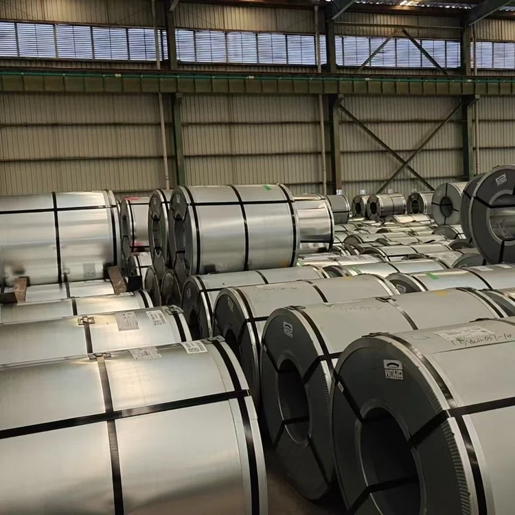 Rows of grain-oriented silicon steel (CRGO) master coils stored on end in a warehouse
