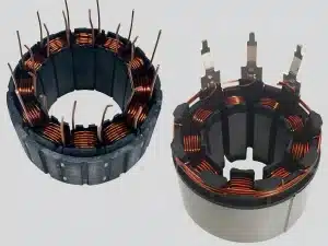 Close-up of a small motor stator core with copper windings wrapped around laminated silicon steel poles