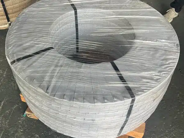 CRNGO steel coil stretch-film wrapped and steel-strapped, eye-to-sky on a wooden pallet