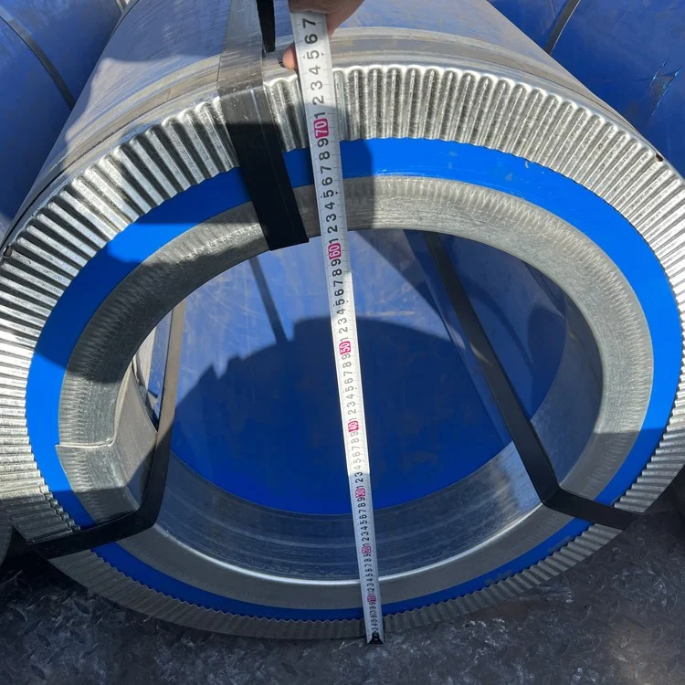 Close-up of a grain-oriented silicon steel coil edge showing the stacked laps of strip and a tape measure across the bore