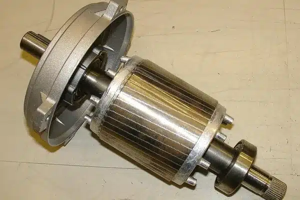Induction motor rotor with a stack of silicon steel laminations between two die-cast aluminum end rings, next to its aluminum end shield