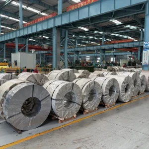 Rows of non-oriented electrical steel coils wrapped and staged in a warehouse