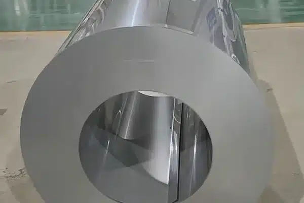Bare GT-100 ultra-thin grain-oriented silicon steel master coil standing on a warehouse floor before slitting