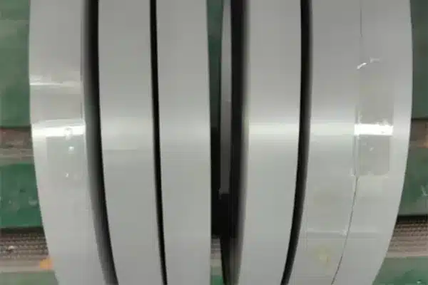 Close-up of 27Q120 slit coil edges showing the grey insulation-coated strip