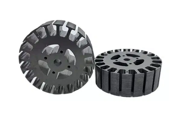 Two motor core stacks with open slots on the outer rim, built from stamped laminations