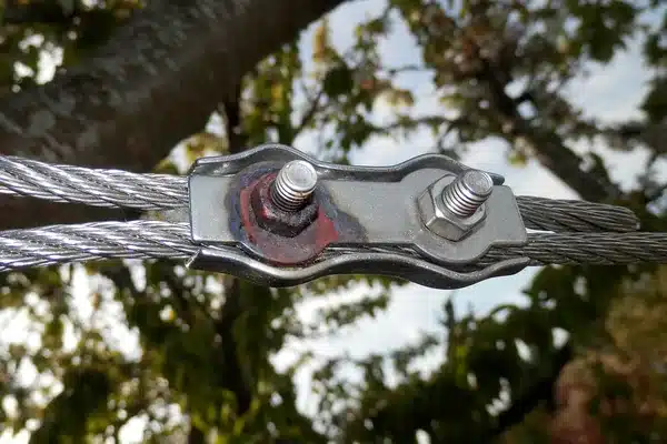 A rusted nut on a stainless steel wire rope clamp, next to a clean stainless nut on the same clamp
