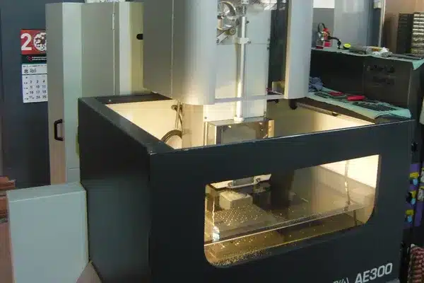 Draht-EDM-Schneidemaschine mit Drahtführungen über einem beleuchteten Arbeitsbecken