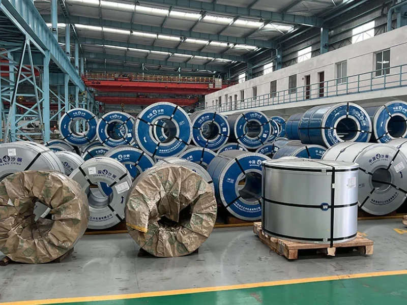 Cold rolled grain oriented steel coils stacked in a manufacturing warehouse